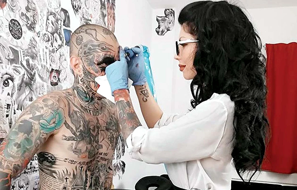 Uglyboy, în timpul procedurii de acoperire a feţei cu un tatuaj realizat de Bianca Iosif