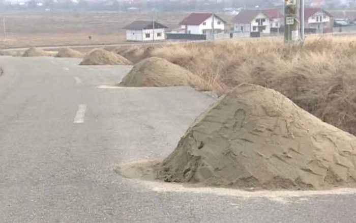 Mormanele cu material antiderapant ocupă o bandă de mers