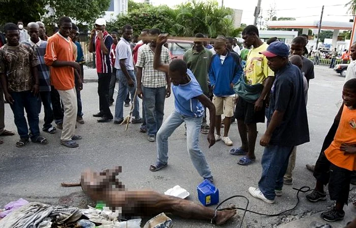 
    Bărbatul din imagine loveşte frenetic un presupus hoţ, a cărui suflare s-a stins de ceva vreme - printre spectatori sunt şi copii (foto: DailyMail)  