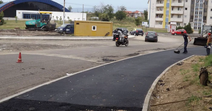 Muncitorii toarnă asfaltul pe trotuarul unde îşi fac veacul prostituatele