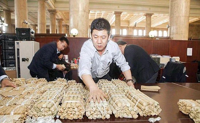 
    Bărbatul  a învelit  monedele  în hârtie  