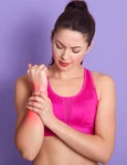 serious brunette young woman with ponytail massages her arthritic hand jpg