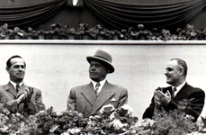 Alexandru Moghioroș, Petru Groza și Gheorghe Gheorghiu-Dej, în tribuna centrală din Piața Aviatorilor la marea demonstrație a oamenilor muncii, în cinstea zilei de 1 Mai 1953 (©  „Fototeca online a comunismului românesc”, cota: 25 (25)/1953)