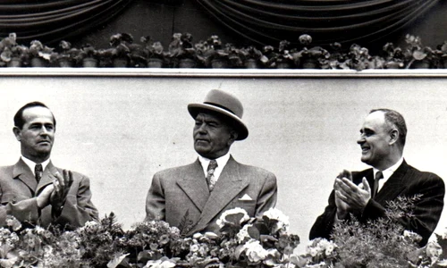 Alexandru Moghioroș, Petru Groza și Gheorghe Gheorghiu-Dej, în tribuna centrală din Piața Aviatorilor la marea demonstrație a oamenilor muncii, în cinstea zilei de 1 Mai 1953 (©  „Fototeca online a comunismului românesc”, cota: 25 (25)/1953)