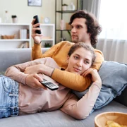 Cuplu care stă la TV și se uită pe telefon FOTO Shutterstock