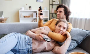 Cuplu care stă la TV și se uită pe telefon FOTO Shutterstock