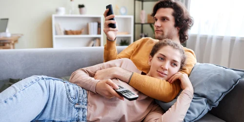 Cuplu care stă la TV și se uită pe telefon FOTO Shutterstock