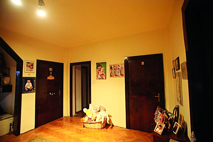În hol, dai cu ochii de multe  fotografii de familie şi de un  coş cu jucării din pluş