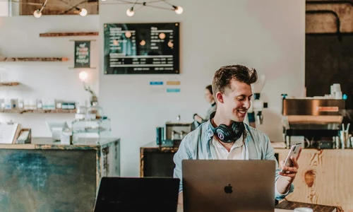 barbat fericit foloseste smartphoneul (Foto: Unsplash)