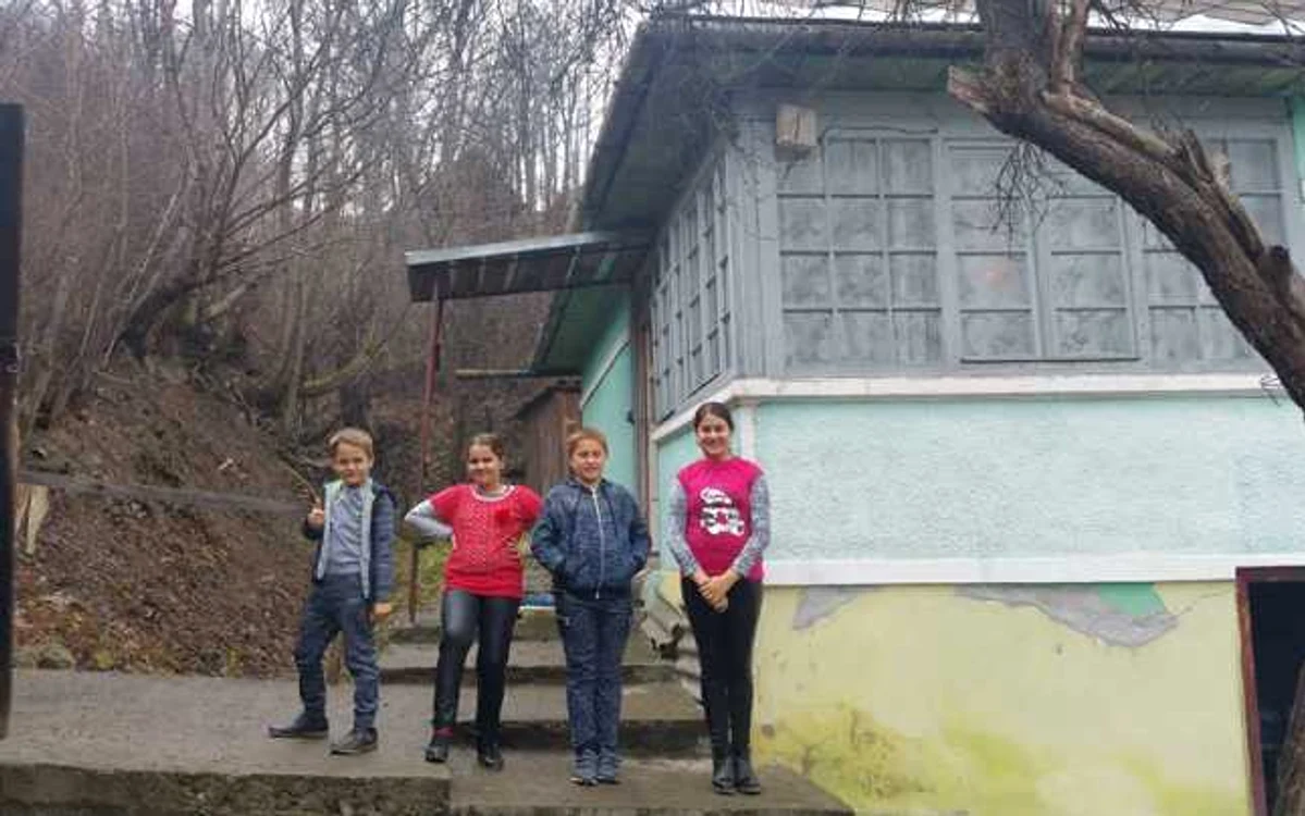 Cei patru copii rămaşi orfani de mamă, în faţa noii lor locuinţe din oraşul Abrud