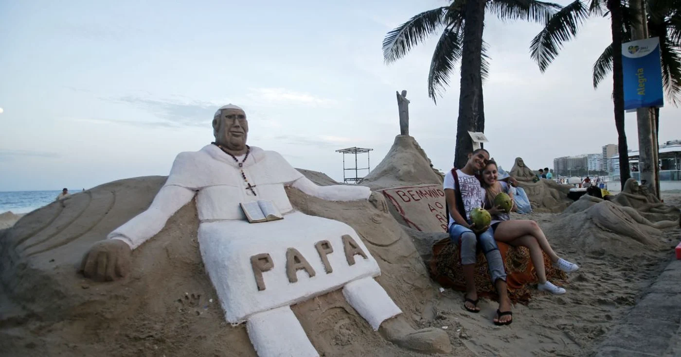 Pentru ZMT a fost realizată o statuie din nisip a Suveranului Pontif. Sculpturile din nisip de pe plaja Copacabana care reprezintă femei goale vor fi „îmbrăcate” pe durata vizitei papei. FOTO: Reuters