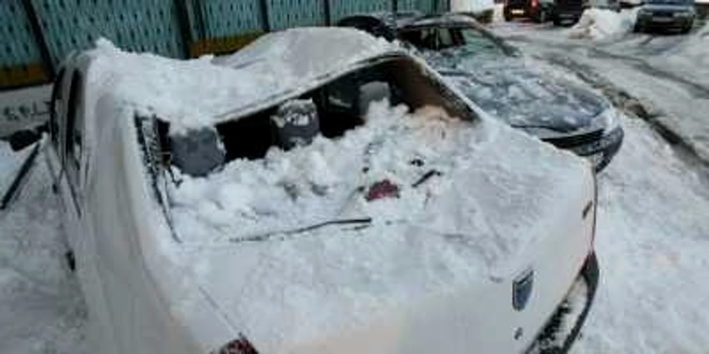 Craiova: Autovehiculele au fost avariate din cauza zăpezii căzute de pe bloc. 