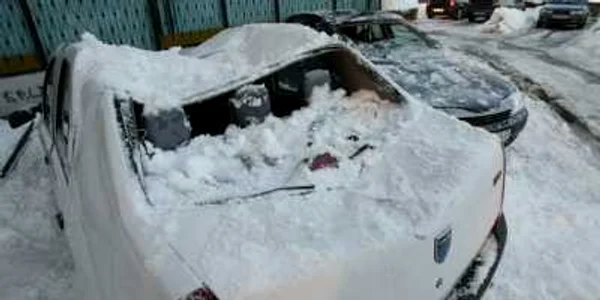 Craiova: Autovehiculele au fost avariate din cauza zăpezii căzute de pe bloc. 