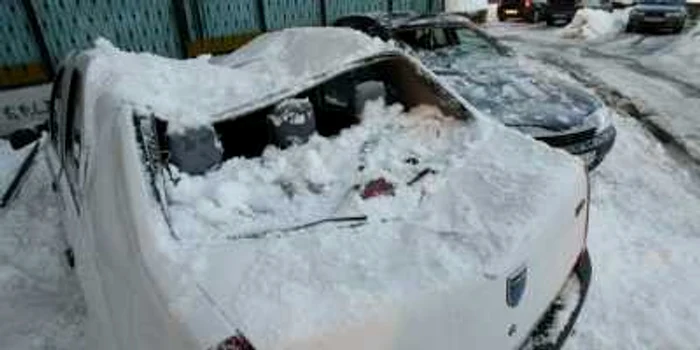 Craiova: Autovehiculele au fost avariate din cauza zăpezii căzute de pe bloc. 