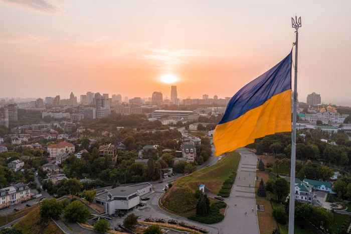 Vedere panoramică a Kievului, cu drapelul ucrainean în prim plan, la apus Foto Shutterstock