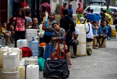 Oameni stau la rand pentru a lua apa Caracas Venezuela FOTO AFP