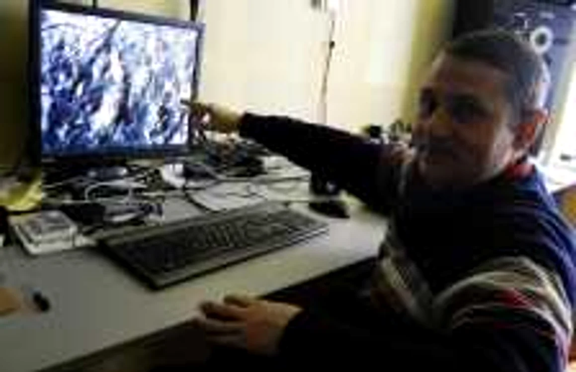 Cristian Mureşanu arată spre copacii surprinşi de camera video cu care a filmat locul