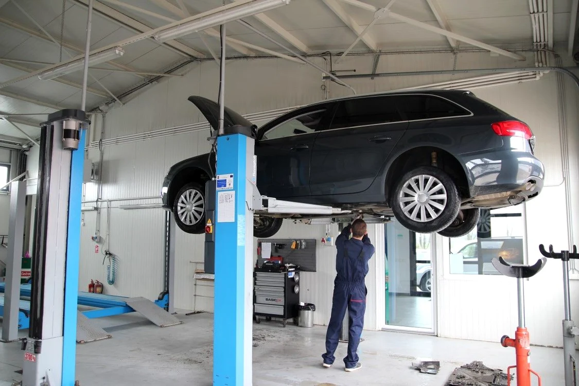 Un mecanic repară o mașină în service