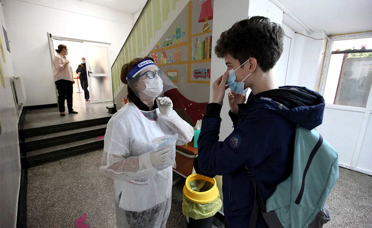 Elevii sunt întâmpinaţi de personal medical, care le ia temperatura şi le oferă măşti de protecţie  