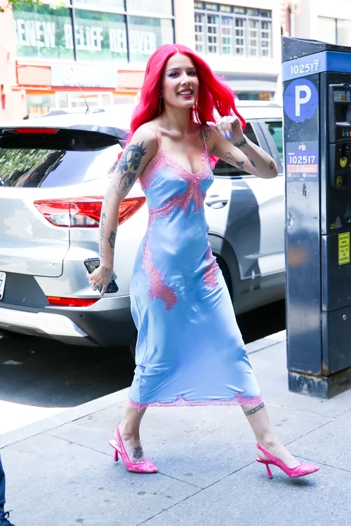 Halsey, cu părul roz și îmbrăcată într-o rochie bleu, pe o stradă din New York. Iulie 2024