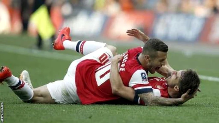 Wilshere (stânga) şi Giroud se bucură după câştigarea Cupei Angliei de către Arsenal. FOTO: Getty Images