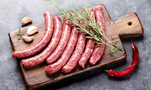 62201689   raw sausages and ingredients for cooking on stone table jpeg