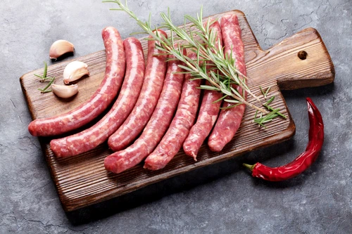 62201689 raw sausages and ingredients for cooking on stone table jpeg