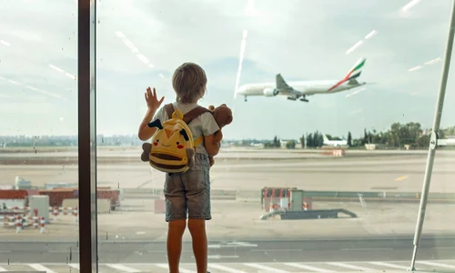 Copil in aeroport cu bagaje -avion pe fundal FOTO Shutterstock 