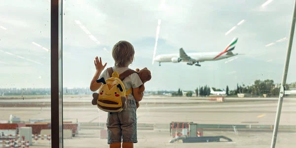 Copil in aeroport cu bagaje -avion pe fundal FOTO Shutterstock 