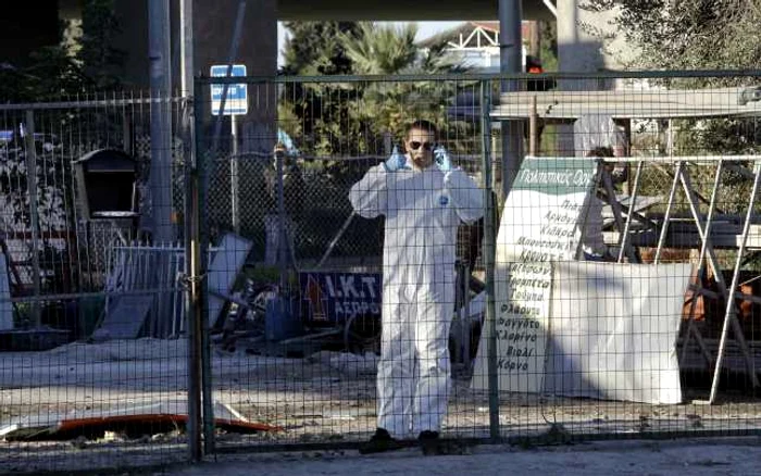 Un parlamentar, membru al partidului extremist de dreapta Zorii de Aur, îmbrăcat într-o uniformă de protecţia, stând de vorbă în faţa filialei locale a partidului, situată în suburbia de vest a Atenei, unde a explodat marţi o bombă FOTO Reuters
