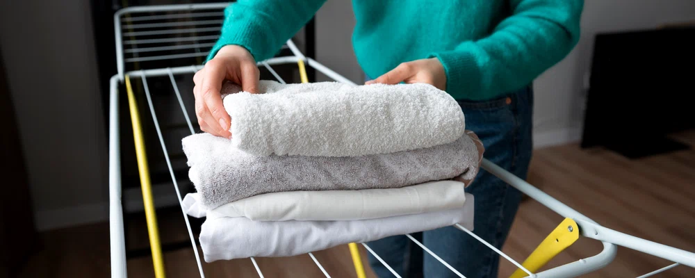 woman folding towels home quarantine copie 2 jpg