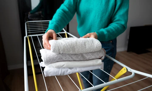 woman folding towels home quarantine   copie 2 jpg