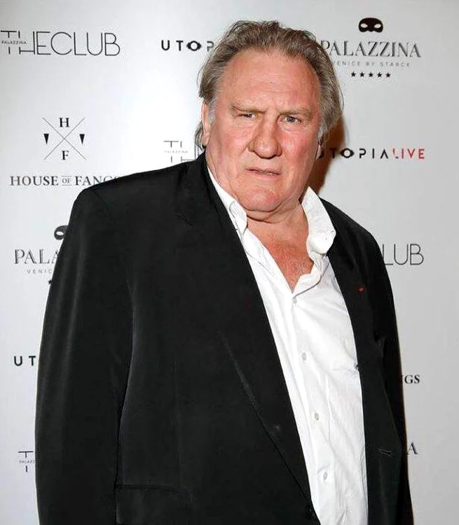 Gérard Depardieu, într-o cămașă albă și sacou negru