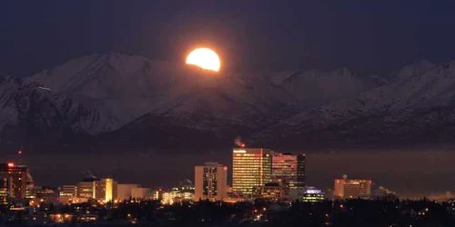 Luna plină se ridică deasupra munţilor Chugach în Anchorage Alaska FOTO AP