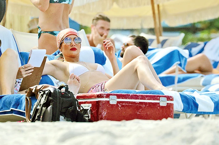 Uite în ce a fost îmbrăcată: 1. eşarfa Valentino 2. ochelari de soare Tom Ford 3. geantă Louboutin 4. pareo de mătase Missoni 5. lănţişar de aur cu diamante 6. costum de baie Khol