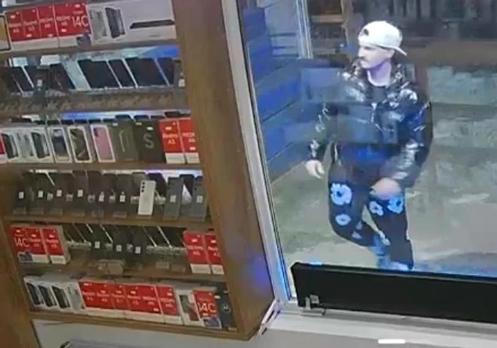 Hoțul a spart geamul magazinului de telefoane FOTO: Captură video