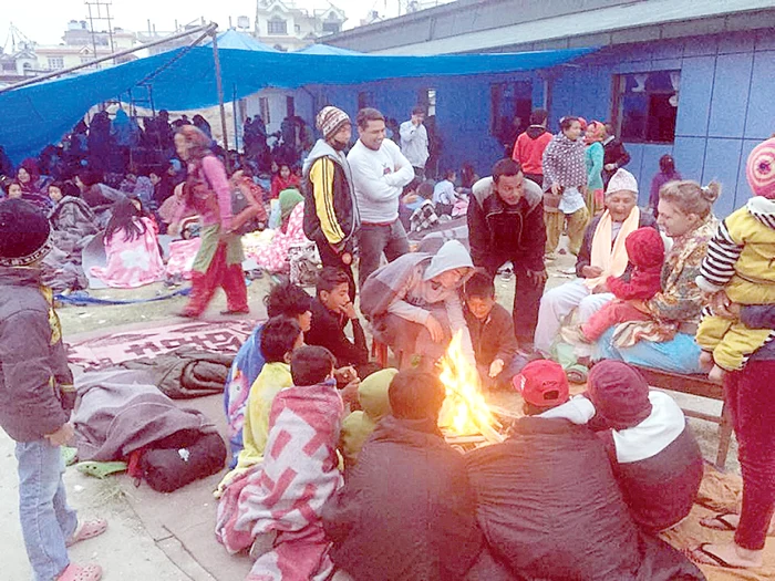 Flavia, cu fiul  ei în braţe, la o tabără improvizată printre dărâmături