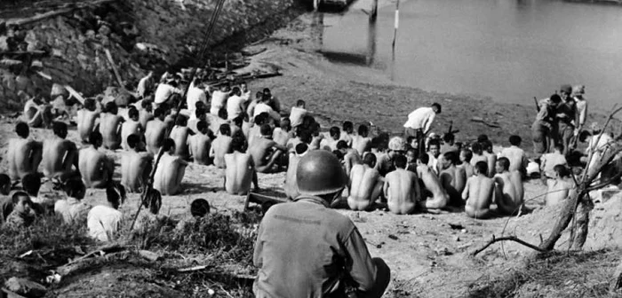 Un soldat american păzeşte prizonierii dezbrăcaţi nord-coreeni în apropiere de Inchon pe 24 septembrie 1950 în timpul Războiului Coreean FOTO AFP