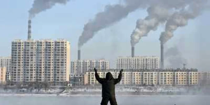 Un bărbat chinez în face exerciţiile fizice de dimineaţă, în spatele unei centrale din Beijing. FOTO: Reuters