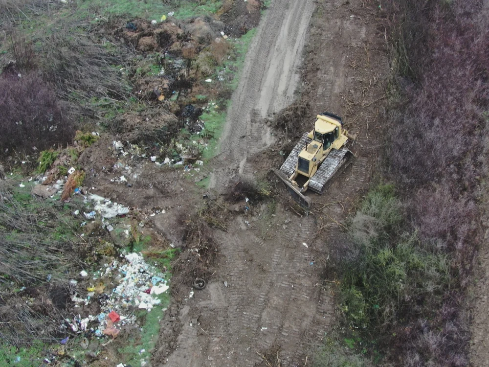 Excavator surprins de dronele Gărzii de Mediu când îngropa gunoaie în Bihor. Reacția primarului