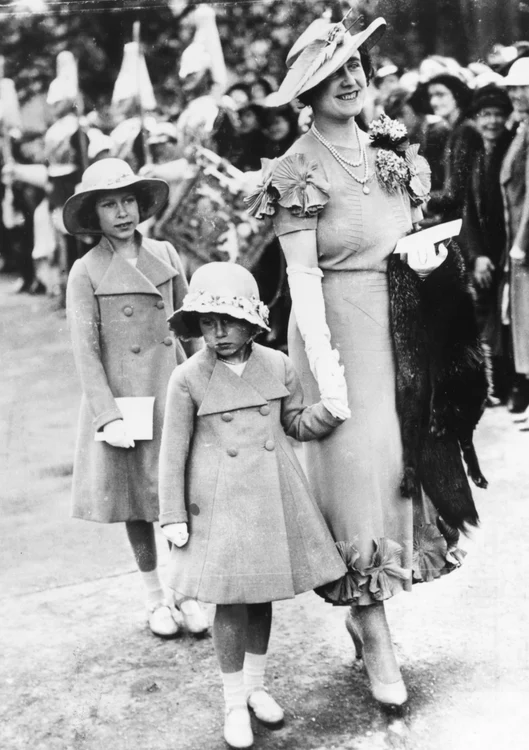 Regina consoartă Elisabeta ținând mâna Prințesei Margaret, în timp ce Prințesa Elisabeta o urmează, participând la nunta de la Elphinstone, 1936, GettyImages 562646011 jpg