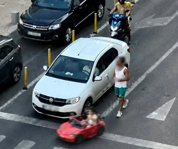 Fetiță plimbată cu mașinuța de jucărie pe șosea, printre mașini Foto: FB 