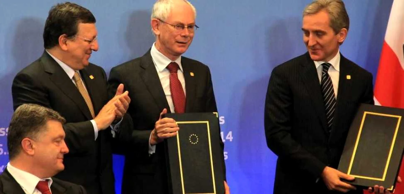 Herman Van Rompuy, preşedintele Consiliului European, şi premierul Iurie Leancă ţin în mâini Acordul de Asociere Republica Moldova-UE. Jose Manuel Barroso, preşedintele Comisiei Europene, şi preşedintele Ucraine Petro Poroşenko aplaudă. FOTO Gov.md