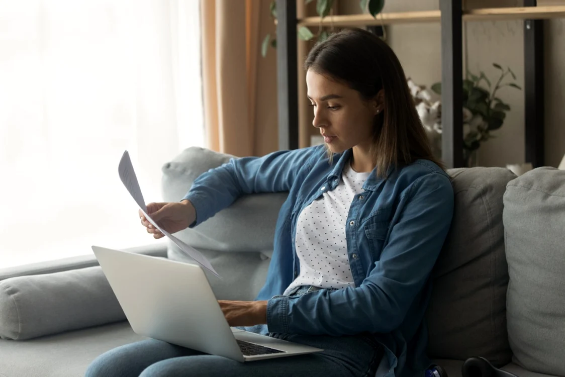 Femeie laptop canapea hârtii