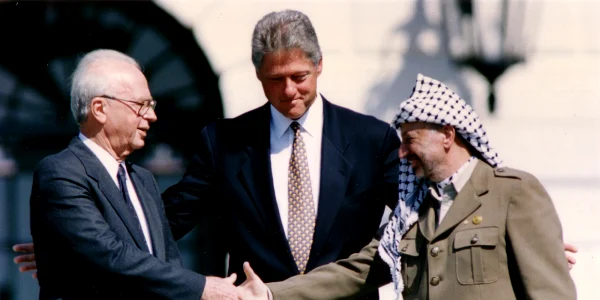 Prim ministrul israelian Yitzhak Rabin (stânga) și liderul palestinian Yasser Arafat ajung la un acord interimar sub privirile președintelui Clinton, la Casa Albă, la 28 septembrie 1995 webp