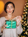 young woman with christmas present by christmas tree (1) jpg