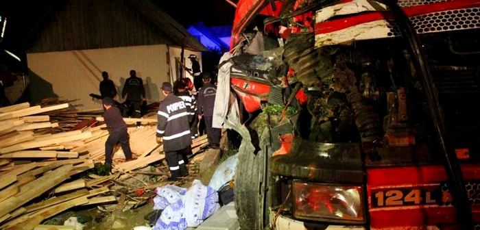 TIR-ul încărcat cu cherestea rasturnat în curtea unei locuinţe din Vama, Suceava. FOTO: Dinu ZARĂ