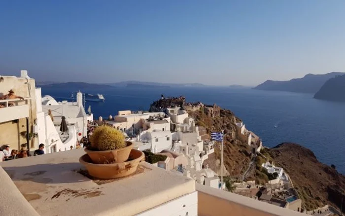 Turiştii pregătindu-se să prindă cel ami bun loc pentru a vedea celebrele apusuri de soare din Santorini - Grecia Foto Daciana Stoica