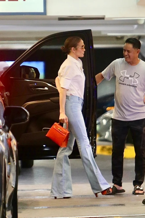 Jennifer Lopez ieșind din mașină, îmbrăcată în blugi albaștri și un tricou alb
