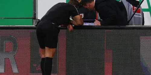 Arbitrul Tobias Stieler verifică un fault pe un monitor în timpul meciului din Bundesliga dintre FC Augsburg şi VfL Wolfsburg desfăşurat pe  WWK-Arena din Augsburg Germania. FOTO Guliver/Gettyimages